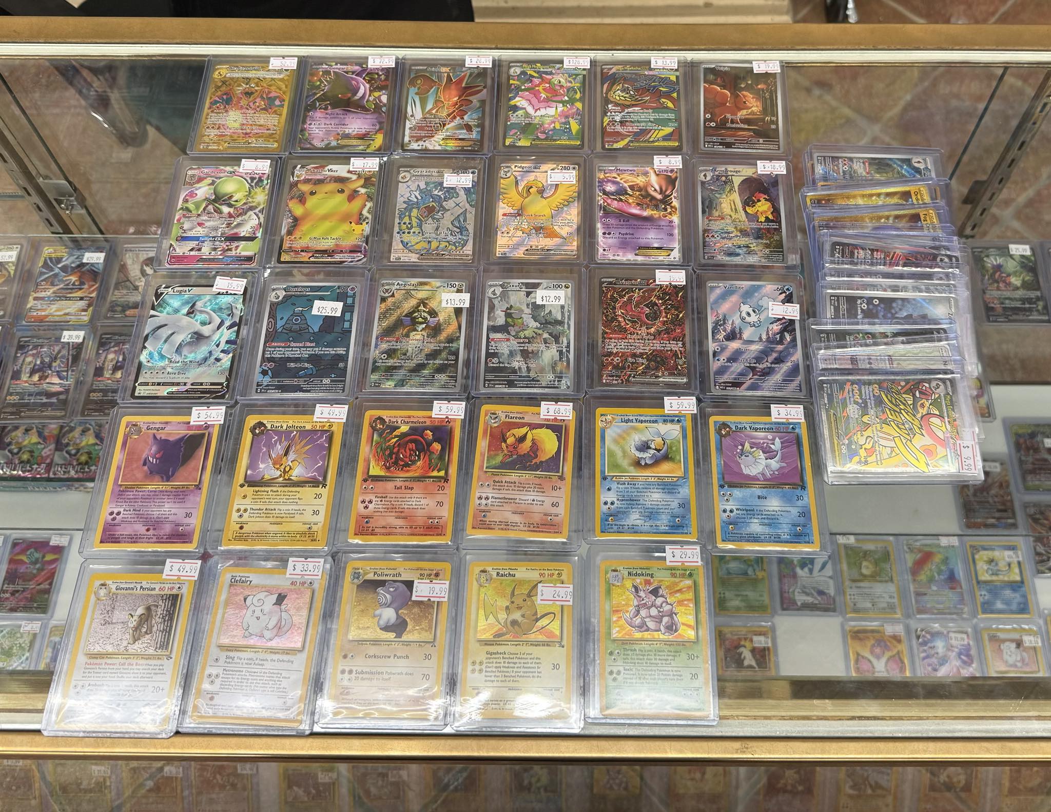 Collection of PSA-graded Pokemon trading cards displayed in a glass case